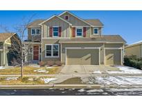 Two-story house with three car garage, red shutters, and landscaping at 9170 Fig St, Arvada, CO 80005