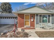 Charming home featuring brick accents, a well-manicured lawn, and an attached garage at 7005 S Ash Cir, Centennial, CO 80122