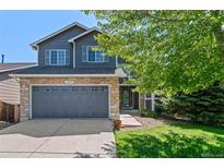 Charming two-story home features a stone facade, gray siding, a two-car garage and a well-manicured lawn at 2629 Wisteria Dr, Erie, CO 80516