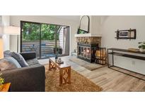 Inviting living room with a stone fireplace, sliding glass doors to balcony, and stylish decor at 7379 S Gore Range Rd # 304, Littleton, CO 80127