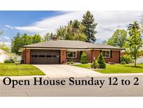 Charming red brick ranch-style home with a well-manicured front lawn and attached two-car garage at 428 W Valleyview Ave, Littleton, CO 80120