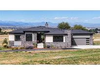 Beautiful single-story home boasts stone accents, a three-car garage, and stunning mountain views at 2730 Fox View Trl, Franktown, CO 80116