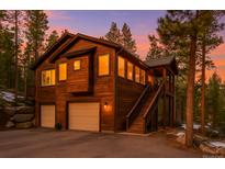 Inviting two-story home featuring a two-car garage and staircase to a cozy outdoor porch at 6752 S Columbine Rd, Evergreen, CO 80439
