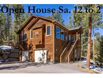 Charming two-story home with natural wood siding and a convenient attached two-car garage at 6752 S Columbine Rd, Evergreen, CO 80439