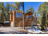 Charming two-story wood home with a welcoming deck and beautiful natural surroundings at 6752 S Columbine Rd, Evergreen, CO 80439