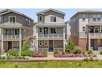 Charming three-story home with a balcony and colorful landscaping at 12714 E Dickenson Ave, Aurora, CO 80014