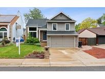 Charming two-story home with a well-maintained lawn, inviting entrance and two car garage at 6342 Marshall St, Arvada, CO 80003