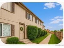 Charming townhome exterior featuring a well-maintained lawn and inviting front entrance with decorative wreath at 2644 Devonshire Ct, Denver, CO 80229