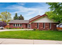 Charming brick home with well-manicured lawn and flower beds at 3608 S Newport Way, Denver, CO 80237