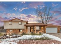 Brick ranch house with attached garage, landscaping, and a tree in the front yard at 1390 E Southern St, Brighton, CO 80601