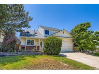 Charming home featuring a well-maintained front yard, brick accents, and mature trees at 5020 E 120Th Pl, Thornton, CO 80241