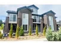 Stylish townhome featuring brick accents, a balcony, and well-maintained landscaping, offering a modern living experience at 14673 E Belleview Dr, Aurora, CO 80015