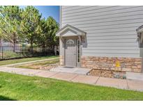 Charming front entry with stone accents and well-maintained landscaping at 10381 Cook Way # 212, Thornton, CO 80229