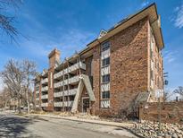 Multi-unit brick building featuring balconies, light-colored trim, and classic architectural details under a clear blue sky at 1366 Garfield St # 209, Denver, CO 80206