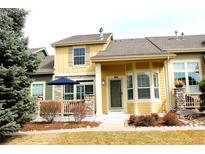 Charming two-story townhome with a covered porch, landscaped yard, and inviting curb appeal at 1104 Rumbling Sky Pl, Castle Rock, CO 80108