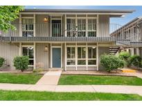 Inviting two-story condo featuring a charming balcony and well-maintained front yard with lush greenery at 6495 E Happy Canyon Rd # 158, Denver, CO 80237