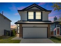 Charming two-story home boasts a well-manicured lawn and attached two car garage at 8827 Cloverleaf Cir, Parker, CO 80134