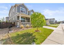 Charming two-story home featuring a covered porch, well-maintained lawn, and inviting curb appeal at 7018 E 123Rd Pl, Thornton, CO 80602