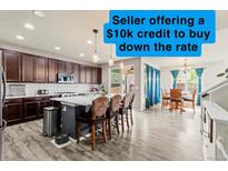 Bright kitchen with island seating, stainless appliances, granite counters, and a $10k rate reduction incentive at 7018 E 123Rd Pl, Thornton, CO 80602
