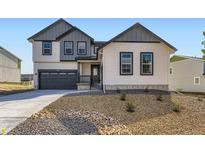 Charming two-story home with a gray garage and rock landscaping in the front yard at 39836 Floyd St, Elizabeth, CO 80107