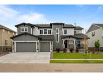 Beautiful two-story home featuring a three-car garage and a well-manicured front lawn at 6737 S White Crow Way, Aurora, CO 80016