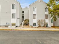 Exterior view of a well-maintained condo building with light gray siding and neatly landscaped surroundings at 3432 S Locust St # A, Denver, CO 80222