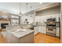 Bright kitchen featuring an island, stainless steel appliances, tile backsplash and modern pendant lighting at 880 E 16Th Ave # D, Denver, CO 80218