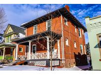 Charming two-story brick home featuring a classic front porch with stately columns at 2631 W 34Th Ave, Denver, CO 80211