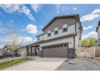 Two-story home featuring a two-car garage, stone accents, and covered porch at 10506 Akron St, Commerce City, CO 80640