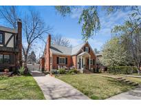 Charming brick home with well-maintained lawn, mature trees, and welcoming front porch offering classic curb appeal at 1615 Kearney St, Denver, CO 80220