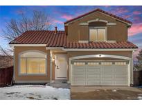 Two-story house with a tan exterior, red tile roof, and a two-car garage at 4575 Gibraltar St, Denver, CO 80249