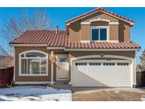 Two-story house with a brown exterior, red tile roof, and a white garage door at 4575 Gibraltar St, Denver, CO 80249