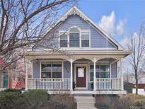 Charming two-story home featuring a covered front porch with decorative trim and a well-maintained yard at 2616 Emporia St, Denver, CO 80238