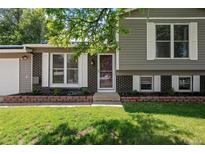 Charming home exterior featuring a brick facade, well-maintained lawn, and beautiful white shutters at 9575 Garland Ct, Westminster, CO 80021