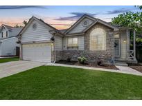 Charming single-Gathering home with stone accents, lush lawn, and attached two-car garage at 3612 Rosewalk Cir, Highlands Ranch, CO 80129