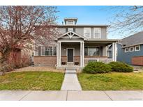 Charming two-story home with a welcoming front porch and well-manicured lawn at 11022 Newark St, Commerce City, CO 80640