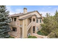 Charming condo with stone accents, private balconies, and lush landscaping under a blue sky at 9944 E Carolina Cir # 201, Aurora, CO 80247