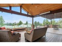Inviting sunroom with comfortable seating, stone accents, and panoramic views of the surrounding landscape at 12665 S Robinson Ranch Ct, Parker, CO 80134