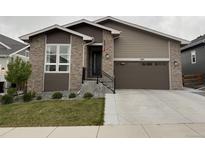 Charming single-Gathering home featuring a brick facade, attached two-car garage, and well-manicured front lawn at 5271 Routt Ct, Arvada, CO 80002