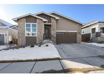 Modern two-story home with brick and siding, attached garage, and snow-covered landscaping at 5271 Routt Ct, Arvada, CO 80002
