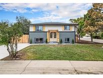 Charming home featuring a well-manicured lawn, modern exterior paint, and a pergola over the front door at 6775 Newland St, Arvada, CO 80003