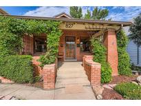 Charming brick home featuring a cozy front porch adorned with climbing greenery and a welcoming entrance at 827 S Sherman St, Denver, CO 80209