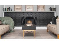 Cozy living room with a brick fireplace, mantle decor, and stylish coffee table at 7391 S Marion St, Centennial, CO 80122