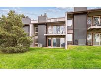 Multi-level townhouse featuring a grassy lawn, private balconies, and outdoor seating at 6515 Pinewood Dr, Parker, CO 80134