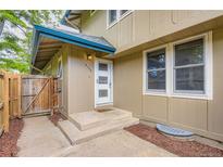 Inviting front entrance with covered porch and well-maintained landscaping, great natural light from windows at 8759 E Roundtree Ave, Greenwood Village, CO 80111