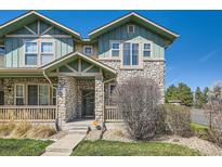Inviting exterior of a two-story home featuring a stone facade and covered porch with craftsman details at 552 S Mobile Pl, Aurora, CO 80017