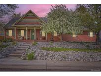 Charming single-Gathering home featuring a cozy front porch and colorful, well-maintained landscaping at 8801 W 65Th Ave, Arvada, CO 80004