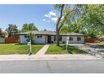 Charming single-story home with a well-manicured front yard and freshly painted white exterior, perfect for suburban living at 8800 W Kentucky Ave, Lakewood, CO 80226