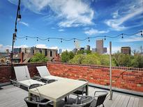 Relaxing roof deck with lounge chairs and outdoor seating area showcasing amazing views of the city skyline at 1130 N Pennsylvania St # 208, Denver, CO 80203