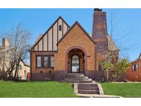 Charming brick home with a distinctive chimney, arched entry, and well-maintained front yard at 2960 Ash St, Denver, CO 80207